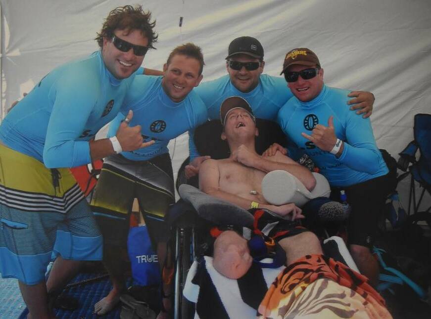 Mateship: Glen Allen, Wes Frazer, Clinton Black and Paul Perry help their friend James Murray enjoy a day with the Disabled Surfing Association South West. Photo: Mick Marlin.