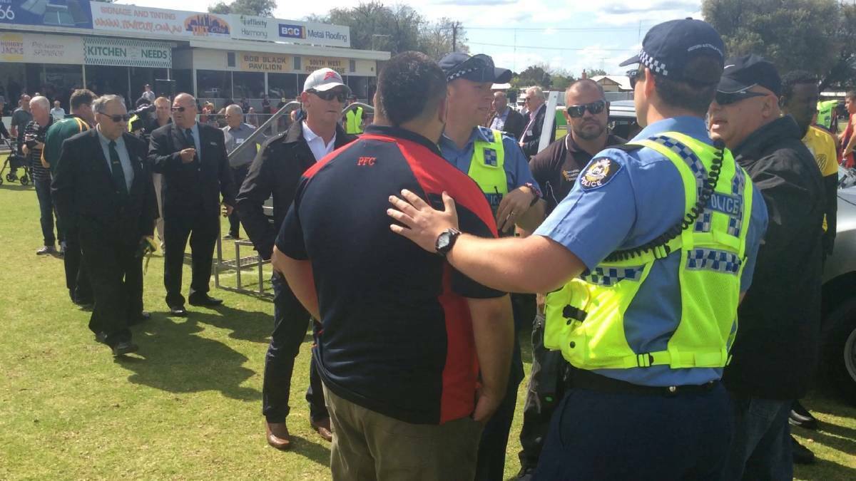Jeffrey Humphries being escorted from the ground by police after punching an umpire following the 2015 South West Football League reserves grand final. 