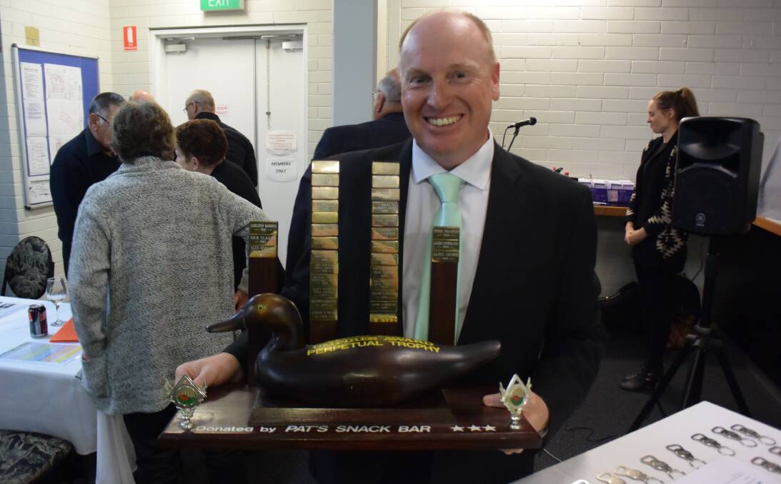 South West Football Leauge Umpires Association president Jason Crowe with the annual wood duck of the year award. Photo: Andrew Elstermann.