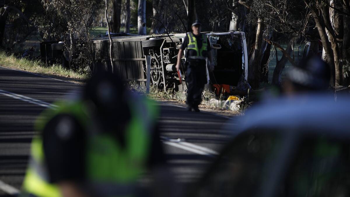 Police inspect the site of the bus rollover near Avoca. Picture: Luka Kauzlaric 