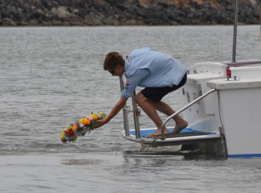 Farewell Scruffy: Family friend Kai Peoples laid the wreath in the water as family and friends came out to bid missing fisherman Jeffrey Doyle goodbye. Photo: Ivy James 
