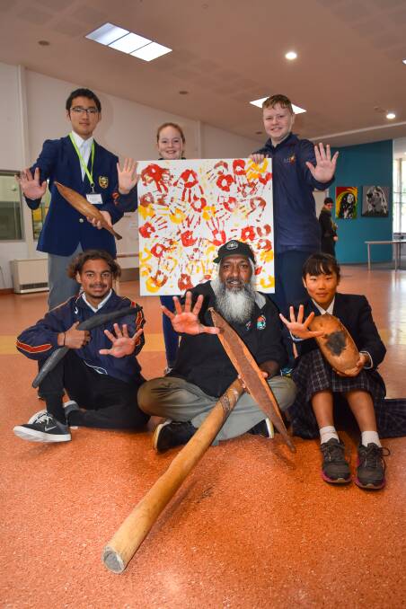 ART AND ARTEFACTS: Sixteen students from Japan visited Eaton Community College and were taught a thing or two about Aboriginal culture from artist Troy Bennell (centre). Picture: Ivy James  