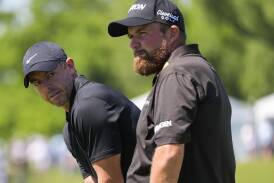 Rory McIlroy (l) kept playing partner Shane Lowry positive during a tough patch in their round. (AP PHOTO)