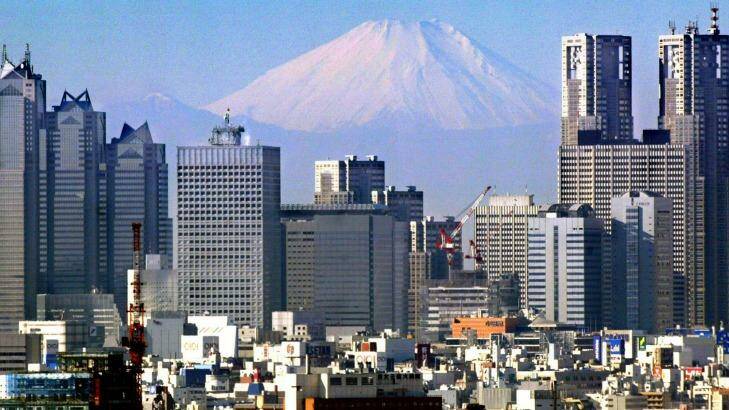 Mount Fuji peaks through the Tokyo skyline.
