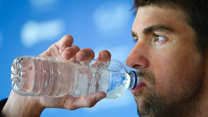 US swimmer Michael Phelps takes a sip of water during a press conference at the Gold Coast Aquatic Centre in Queenland's Gold Coast. AFP PHOTO / PATRICK HAMILTON Photo: PATRICK HAMILTON