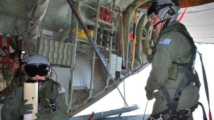 Narrowing the search area ... Loadmasters Sergeant Adam Roberts (left) and Flight Sergeant John Mancey prepare to launch a water-activated buoy from the Hercules C-130J. Photo: Liam Ducey