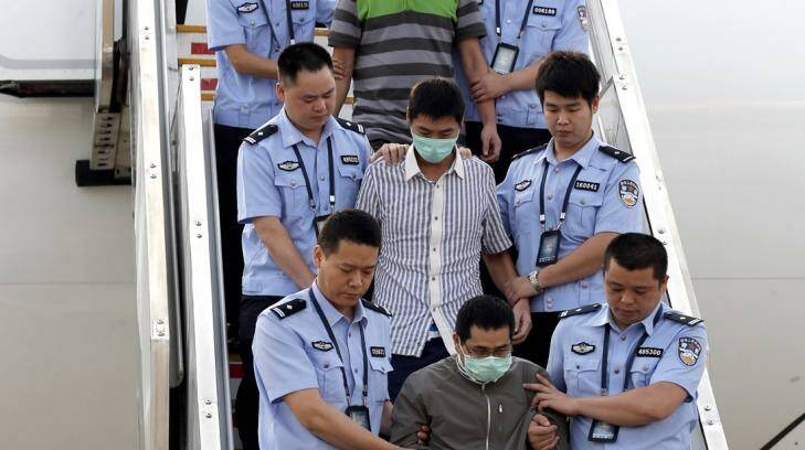 Six accused fugitives are taken back to China under escort from Indonesia in June 2015. Photo: Xinhua/AP