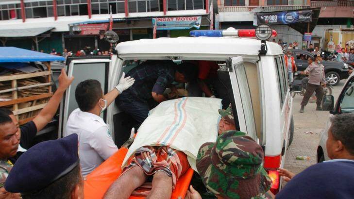 A victim of the earthquake is loaded into an ambulance in Pidie Jaya regency. Photo: Jefri Tarigan