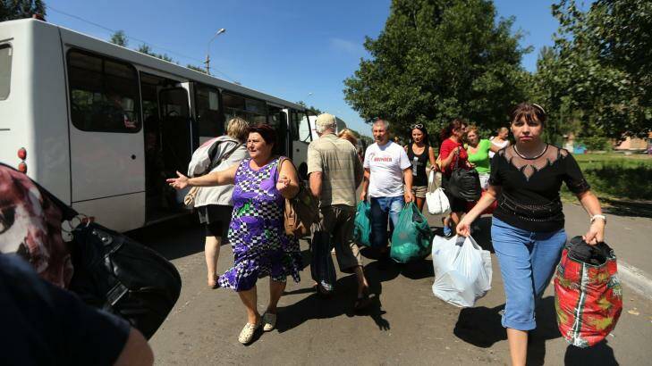 Fleeing residents of Shakhtersk run towards buses provided by pro-Russian rebels after heavy shelling. Photo: Kate Geraghty