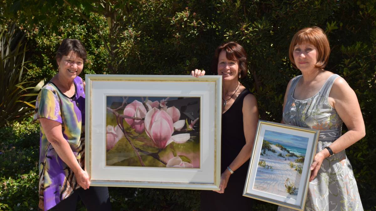 Pam Teede, Lee Raper and Jackie Price of the Australind Art Club show off the two paintings donated for their fundraising raffle.
