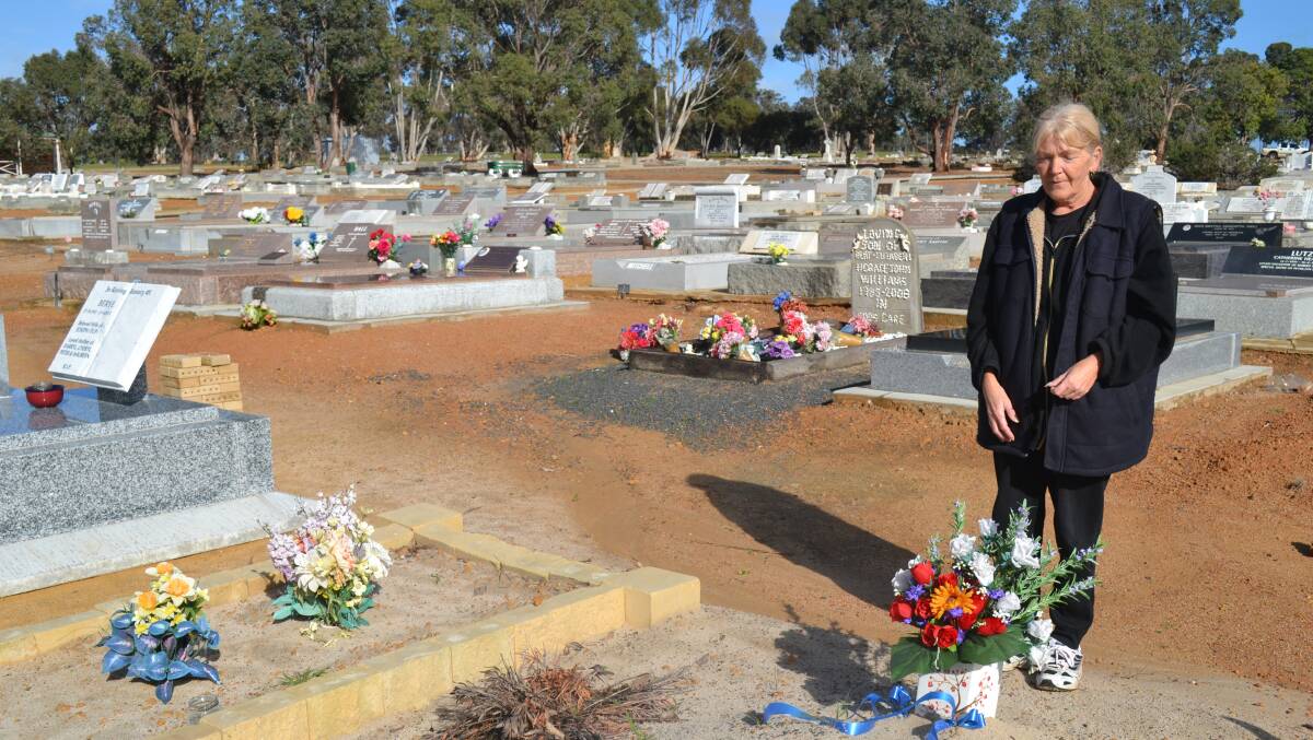 Carol Stanley stands at her son's grave.