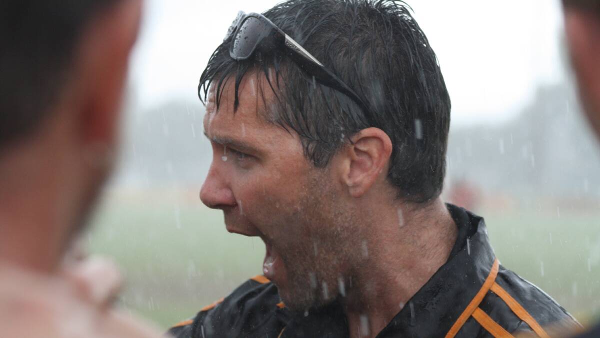 Bunbury coach Ryan Pitts got soaked while addressing his boys at quarter-time. Photo: Andrew Elstermann. 