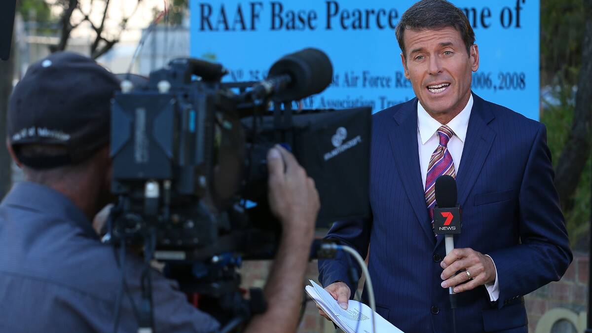  A television reporter performs a live news cross from the Pearce RAAF base on March 20. Pic: Getty Images