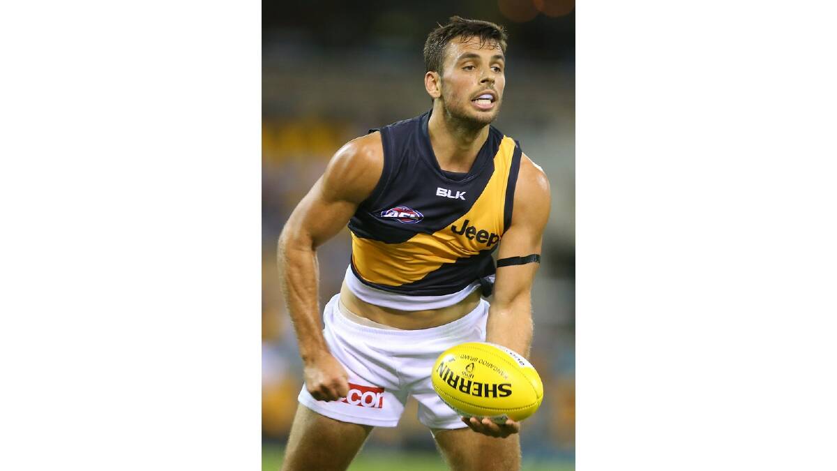 Sam Lloyd of the Tigers handballs during the round five AFL match between the Brisbane Lions and the Richmond Tigers at The Gabba on April 17, 2014 in Brisbane, Australia. Photo: Chris Hyde/Getty Images.