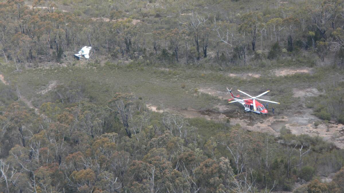 CRASH SITE: The Ambulance Rescue helicopter at the scene of Thursday’s plane crash north of Nerriga. The photo was taken from the Australian Maritime Safety Authority Dornier search and rescue aircraft. 