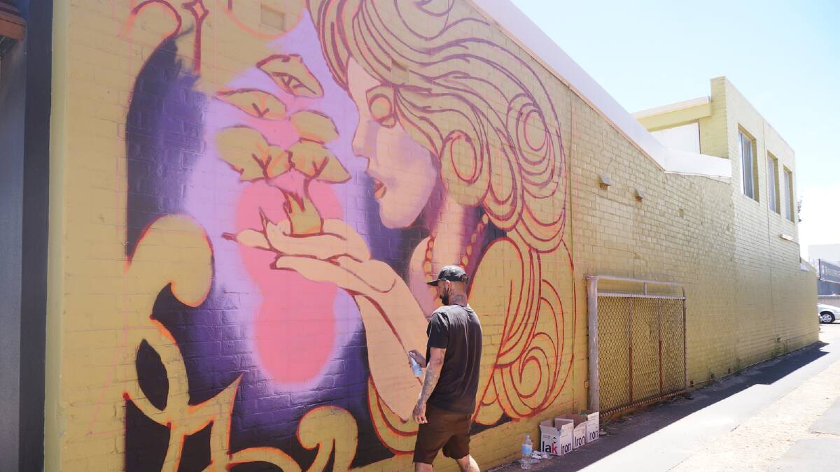 Bunbury artist Tim Howe brings life to the Good Earth Surf Shop wall on Wellington Street. 