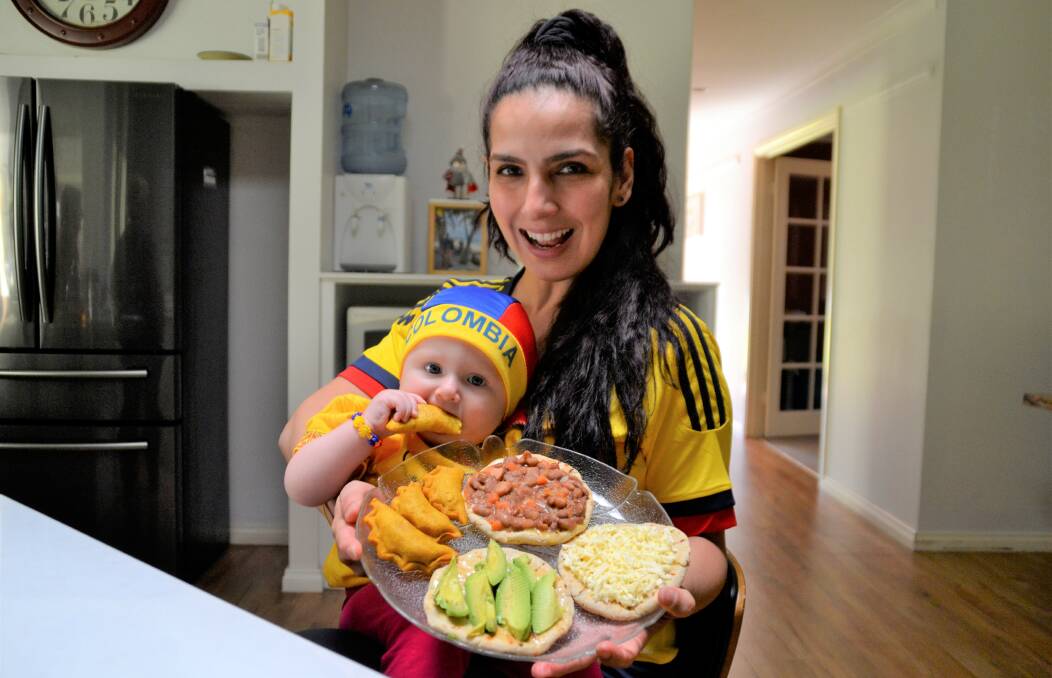 'Passing down traditions': Yury Jaramillo with her seven-month-old daughter, Sara Doust, in their matching Colombian football outfits. Photo: Pip Waller. 