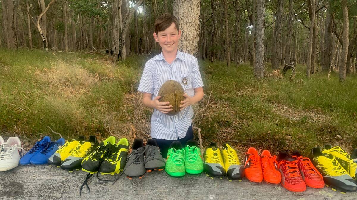 Henry Winspear with his footy boots ready for donation. Photo is supplied.