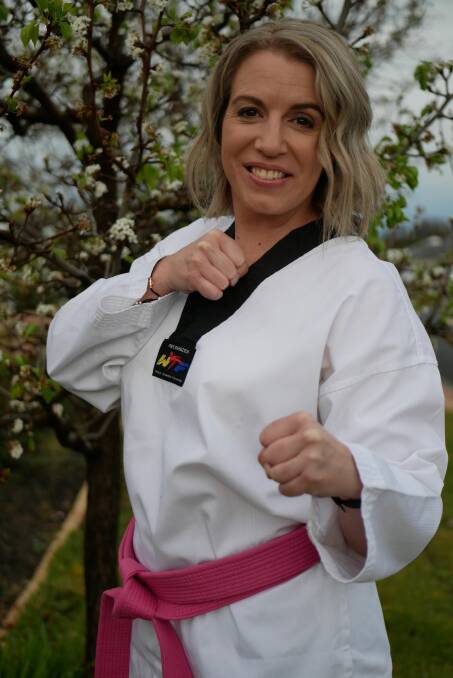 Kristy Hitchens wearing one of the pink belts that scholarship recipients receive. Photo is supplied.
