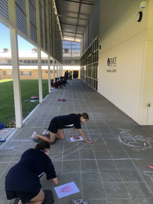Students enjoying lining out their art works on the pavement. Picture: supplied 