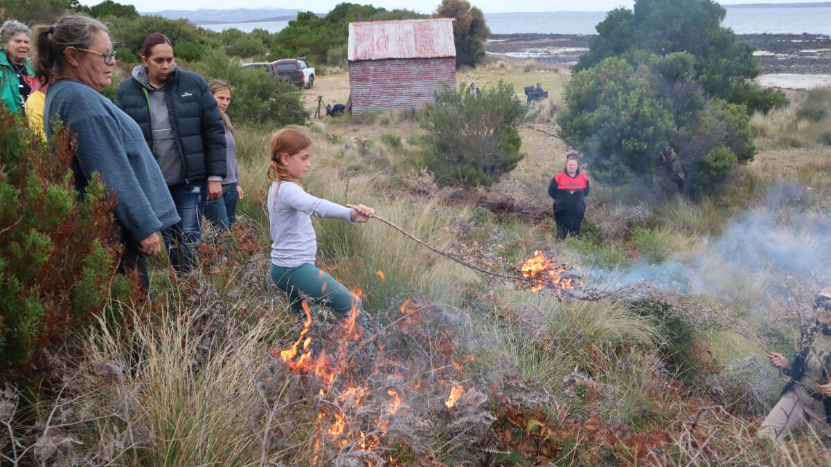 River Cavanagh, 10, burning on Truwana country, Cape Barron Island in Tasmania, has taken part in cultural burns with mum Rachael most of her life. Picture supplied