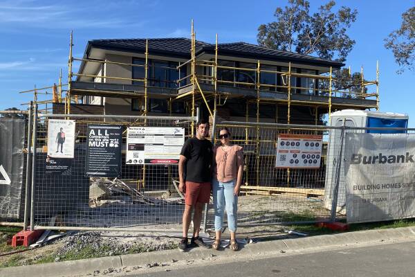 Alanna Tomazin with her brother, Nicolas, in front of the partially-built family home they bought in the NSW Hunter region to help their parents. Picture: Supplied