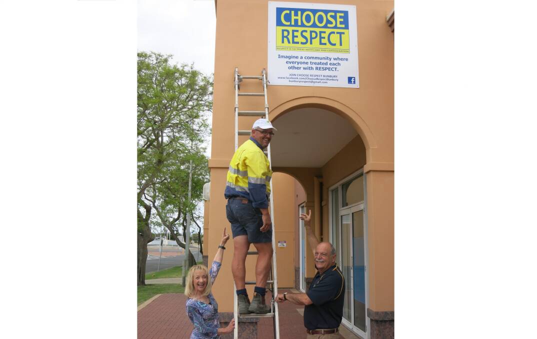 Choose Respect Bunbury Patron John Castrilli and Nola Marino MP hold the ladder steady as Shane Jackson from Smith Constructions puts the finishing touches on the new Choose Respect signage.