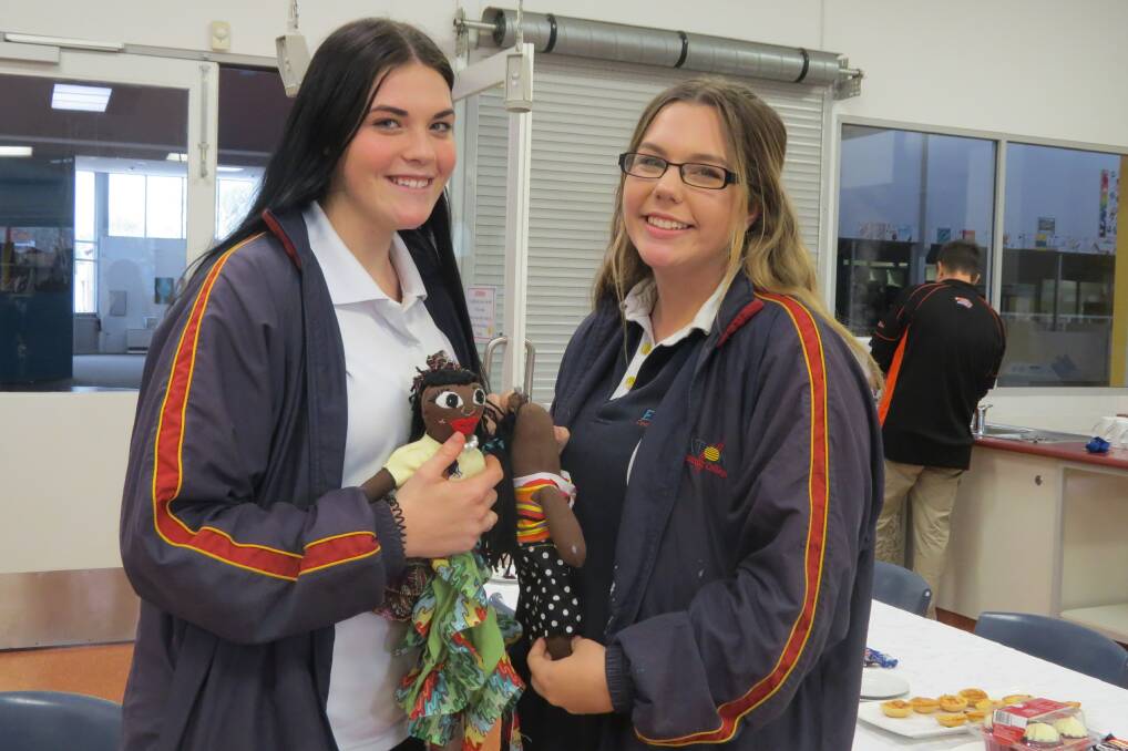 Eaton Community College students Jazmin Bestwick and Abbey Jones with the dolls they hand made for the Uthando Project. 