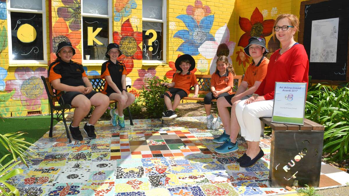 Teacher Megan Cooper joins students from Cooinda Primary School in the conversation corner to celebrate their school's recognition in the 2017 Act Belong Commit awards. 