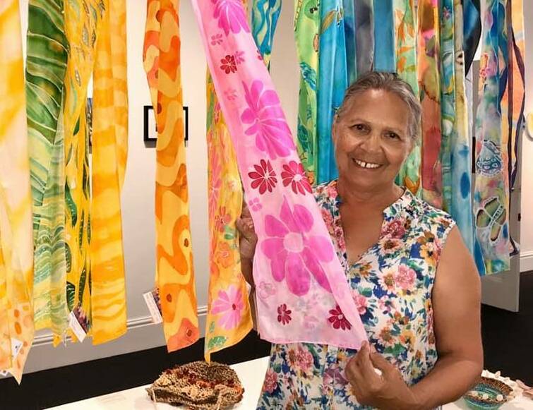 Artist Dawn Alone with the silk scarves created by local indigenous artists. Photo: Supplied. 