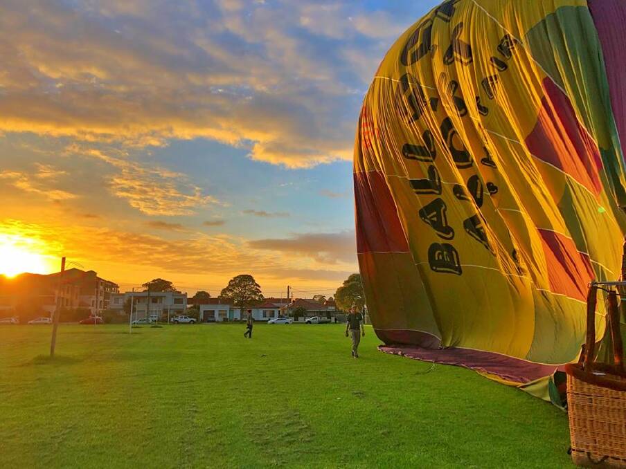 DAWN ADVENTURE: The sun rises over Fairy Meadow as the balloon comes down at Guest Park. Picture: Clément Seigeot