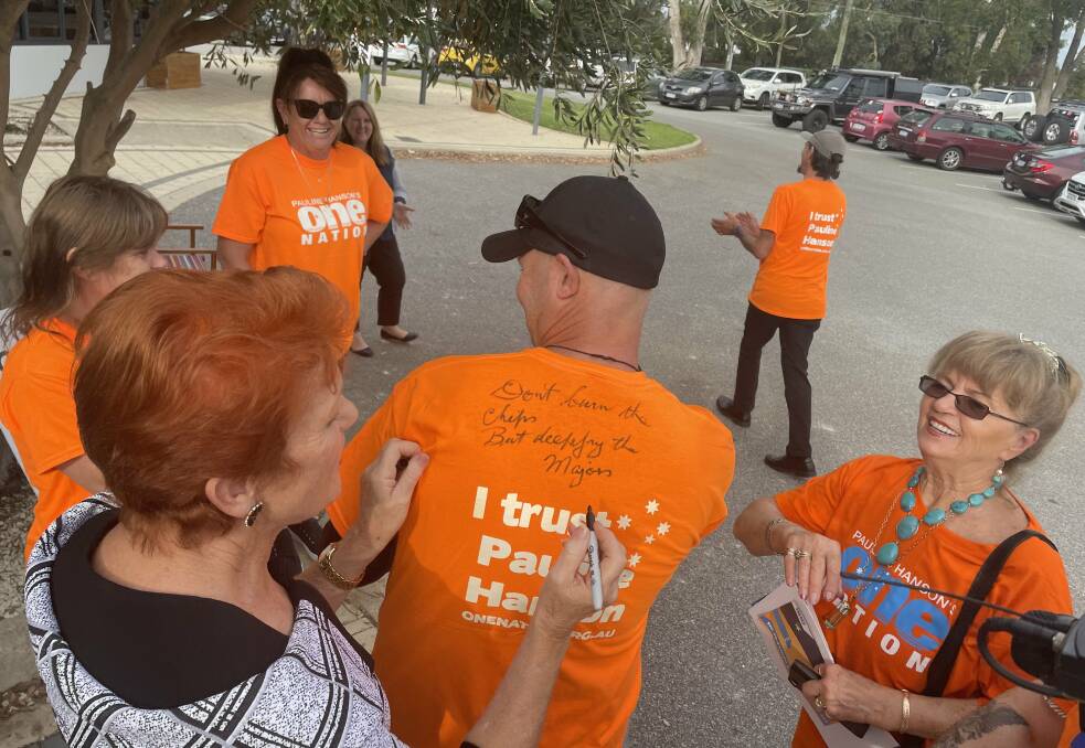 One Nation Party Leader Pauline Hanson signing a volunteer's shirt with the phrase, "Don't burn the chips but deep fry the majors". Picture: Perri Polson. 