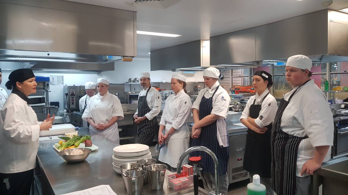  A group of apprentice chefs and commercial cookery students are briefed on the competition by South Regional TAFE lecturer Amanda Smith prior to the event. 