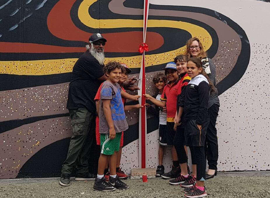 Artist Troy Bennell, Djidi Djidi Aboriginal School students and Holcim WA manager Rebecca Reeves were excited to officially cut the ribbon and open the 16 metre long artwork.