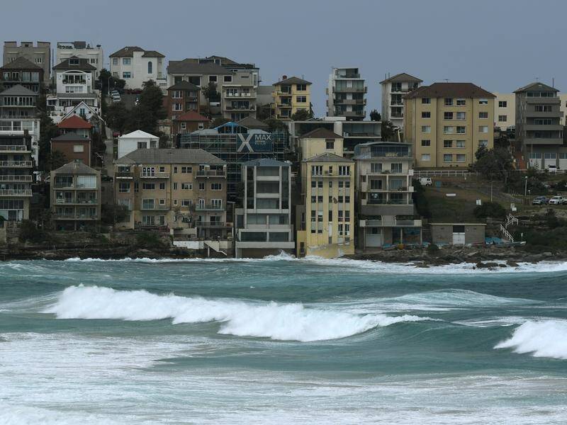 A 47-year-old man has died after he and a woman were swept off rocks by a large wave at North Bondi.