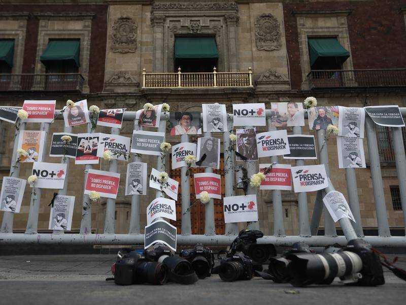 Posters, flowers and cameras outside Mexico City's National Palace in protest at journalist murders. (EPA PHOTO)