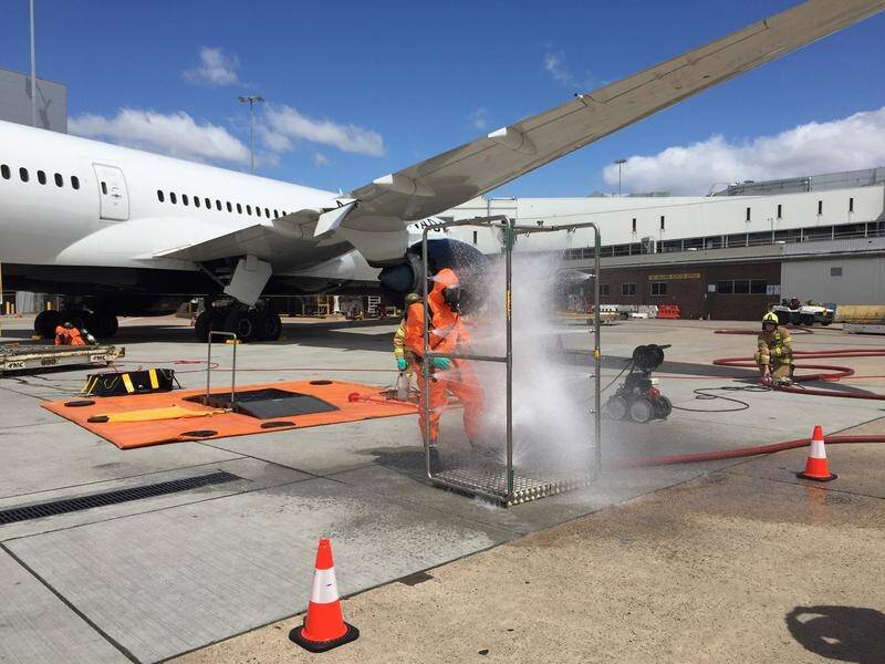 Firefighters conduct safety checks after the discovery of an unknown substance at Melbourne Airport.