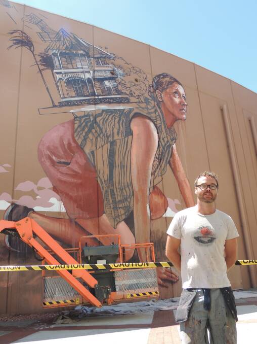 Fintan Magee in front of his artwork