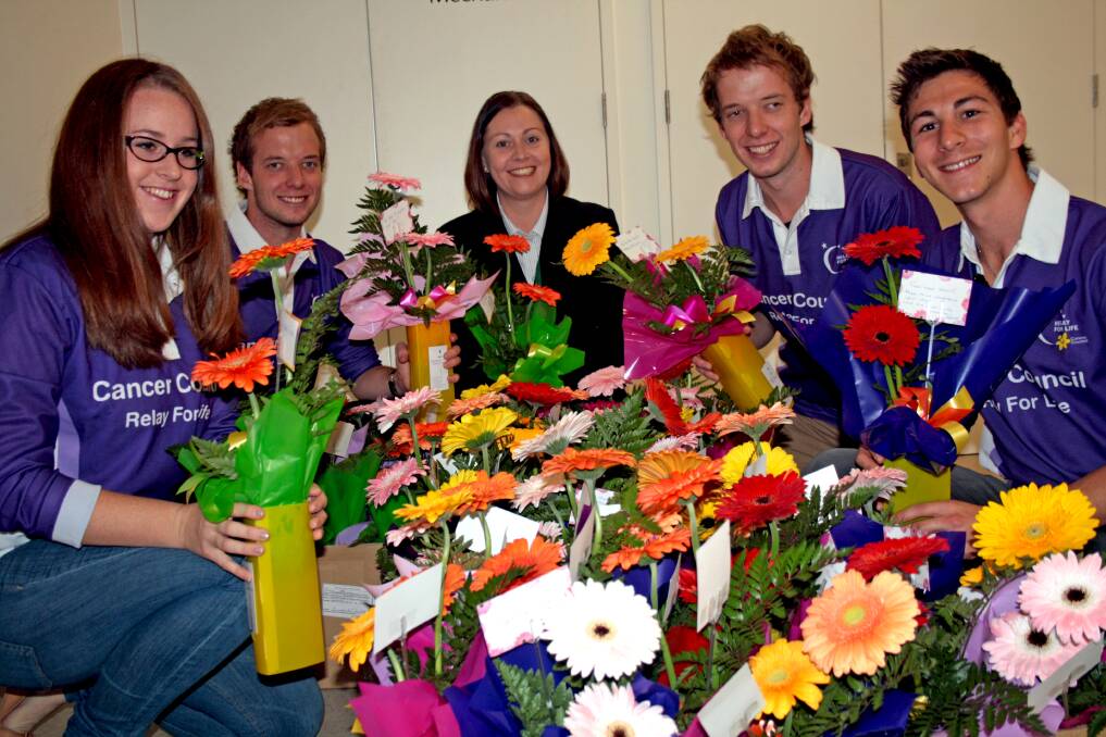 Relay for Life Team Orange members Jayllee Carter, Damien and Aaron Pittard and Nathan Papas donating floral arrangements from Bunbury’s Amazing Race to St John of God Hospital nurse unit manager Nicole Scott (centre).