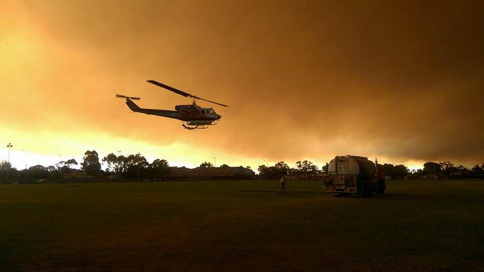 A firefighting helicopter fueling up an oval in Harvey on Thursday night. Photo: Monique Warnock. 