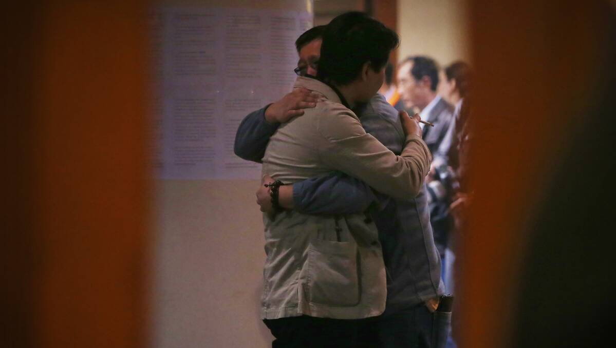 Chinese relatives of the passengers onboard Malaysia Airlines flight MH370 hug each other as they wait for the latest information at Lido Hotel on March 20, 2014 in Beijing, China. Photo: Getty Images.
