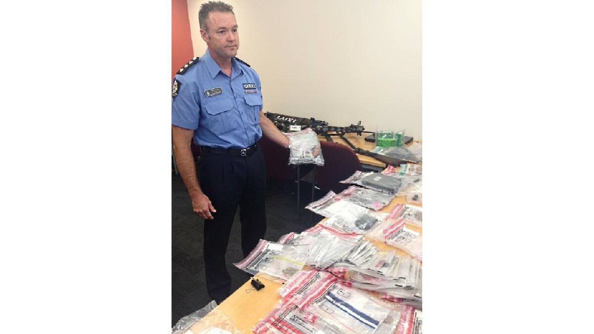 A Bunbury police officer displays some of the seized goods.
